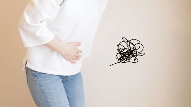 生理痛の痛みでお腹を押さえる女性のイメージ画像